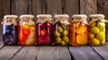 A row of jars filled with a variety of vegetables including pickles, peppers, and carrots