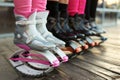 Row of kangoo jumps boots at womens legs. group of girls at fitness workout