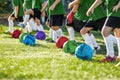 A row of kids soccer players with colorful balls on a training grass pitch. Children playing sports ball outdoor. Royalty Free Stock Photo