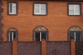 A row of large windows on the brown brick wall of a private house on the street Royalty Free Stock Photo