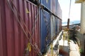 Row of lashed containers in a line with bars and twist locks situated in forward of container vessel.