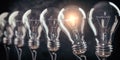 Row of light bulb with a one glowing. Idea and innovation concept Royalty Free Stock Photo