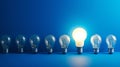 Row of Light Bulbs on Blue Background - Bright Ideas for Illuminating Spaces Royalty Free Stock Photo