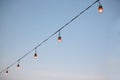 Row of light bulbs turned on over evening sky background Royalty Free Stock Photo