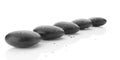 Row or line of black pebbles with water drops on white background, zen, spa, yoga or meditation concept Royalty Free Stock Photo