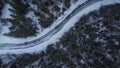 Row or line of cars ligned one after another on an icy and snowy road in norway in sweden meandering around the trees. Vertical Royalty Free Stock Photo