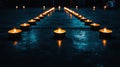 A row of lit candles on a wet concrete floor. Royalty Free Stock Photo