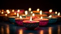 A row of lit ceramic votives next to each other, in the style of indian traditions, glowing colors, religious symbolism Royalty Free Stock Photo