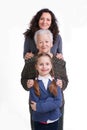 Row of little girl, grandmother, mother looking at camera in lin