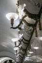 Row of luxurious wall lamps and stucco ornaments on the white glossy marble walls. Royalty Free Stock Photo