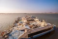 Row of luxury yachts docked on the shore against sunset