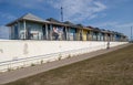 Row of many colorful and different beach huts with a blue sky background. Royalty Free Stock Photo