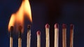 A row of matches where two burning matches pass their fire to the next. Cascade of flame, transfer of energy. Macro shot