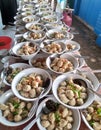 A row of meatballs in a bowl complete with various herbs and spices neatly