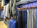 A collection of elegant men\'s trousers and casual pants hanging in a row in a men\'s fashion store Royalty Free Stock Photo