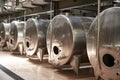 A row of metal vats in a modern winemaking facility