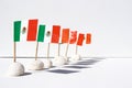 A row of mini Mexican flags with shadows on a white canvas background