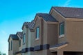 Row of modern house buildings in late afternoon shade with desert adobe colors brown and beige in modern neighborhood Royalty Free Stock Photo