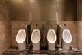 Row of modern urinals men public toilet room in public toilet, restroom in restaurant or hotel or shopping mall, interior Royalty Free Stock Photo