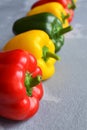 Row of multi-colored fresh bell peppers. Green, red and yellow vegetables. Organic healthy food concept Royalty Free Stock Photo