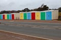 A row of multi coloured beach huts stands attractively by the main coast road in Exmouth, Devon Royalty Free Stock Photo