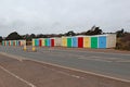 A row of multi coloured beach huts stands attractively by the main coast road in Exmouth, Devon Royalty Free Stock Photo