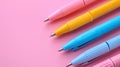 A row of multicolord pens on pastel pink background. Royalty Free Stock Photo