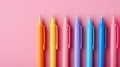 A row of multicolord pens on pastel pink background. Royalty Free Stock Photo