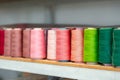 Row of multicolored thread spools at sewing factory Royalty Free Stock Photo