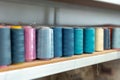 Row of multicolored thread spools at sewing factory Royalty Free Stock Photo