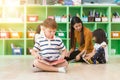 Row of multiethnic elementary students reading book in classroom. Vintage effect style pictures Royalty Free Stock Photo