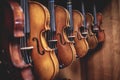 Row of multiple violins hanging on the wall, musician workshop Royalty Free Stock Photo