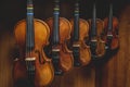 Row of multiple violins hanging on the wall, musician workshop