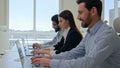 Row of multiracial customer support agents provide service with laptops smiling professional business team programmers