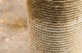 Row of natural beige rope horizontal row wound on a log close-up a column with jute on a blurry ground background