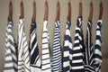 A row of navy striped tops for women on wooden hangers in a closet