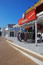 A row of neat commercial retail double storey shops in white with polo sport shirt at Puerto del Carmen, Lanzarote island, Spain