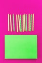 Row of neon green candles on pink background