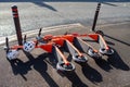 A row of Neuron e-scooters for hire, blown to the ground on a windy day.