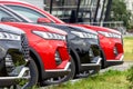 Row of new black and red cars in the dealership parking lot. Close-up of the front parts of cars in the parking lot of a Royalty Free Stock Photo