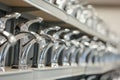 row of new chrome kitchen sink faucets displayed on shelf Royalty Free Stock Photo