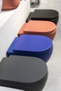 A row of new colored toilet bowls