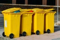 Row of new yellow waste containers on the street