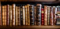 A row of old antique leather-bound books on a bookshelf in a library - wide panoramic banner conceptual wisdom and knowledge