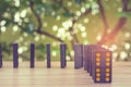 Row of old black color dominoes with colorful dot pieces on wooden floor with green trees in the background. Royalty Free Stock Photo