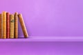 Row of old books on purple shelf. Horizontal background Royalty Free Stock Photo