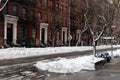 Row of Old Brick Apartment Buildings in Hell`s Kitchen of New York City along a Street with Snow during Winter Royalty Free Stock Photo
