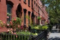 Row of Old Brick Residential Buildings with Colorful Flower Gardens along a Sidewalk in Greenpoint Brooklyn New York Royalty Free Stock Photo