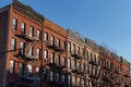 Row of Old Brick Residential Buildings Shining in the Sun with Fire Escapes on the Upper West Side of New York City Royalty Free Stock Photo