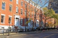 Row of old historic brownstone buildings along an empty sidewalk block in the Greenwich Village neighborhood of Manhattan